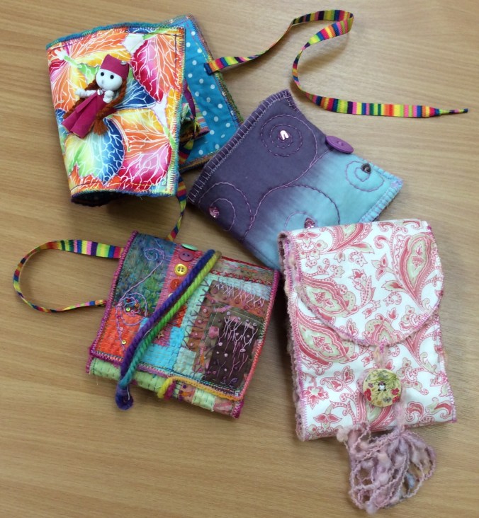 A variety of pocket books created using different fabrics.